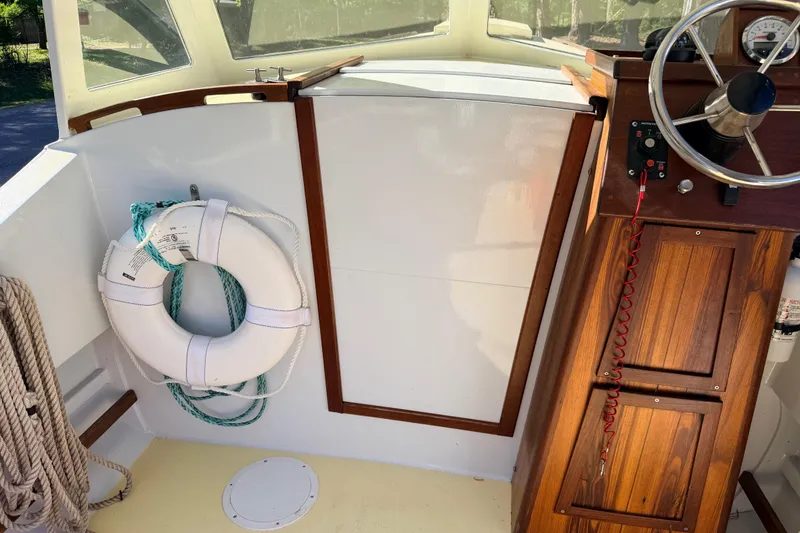 Slide: The Image of Interior of 2018 Custom Loon boat with wooden helm, life preserver, and ropes. - 33
