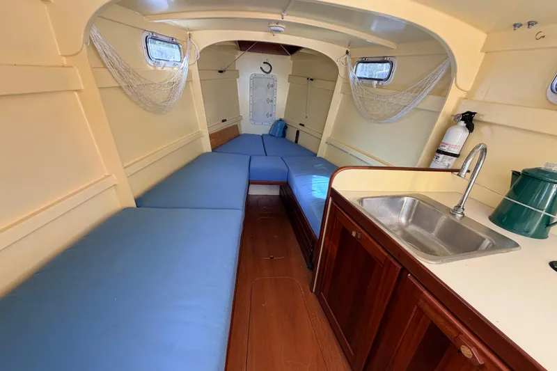 Slide: The Image of Interior of 2018 Custom Loon boat with blue seating, kitchenette, and wooden cabinetry. - 36