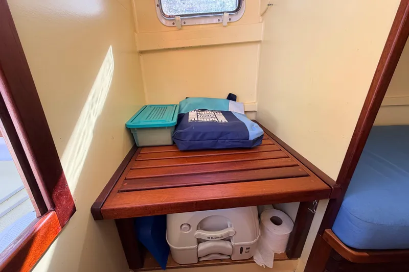 Slide: The Image of Compact boat cabin with wooden shelf, storage containers, and portable toilet. Custom Loon 2018 model. - 48