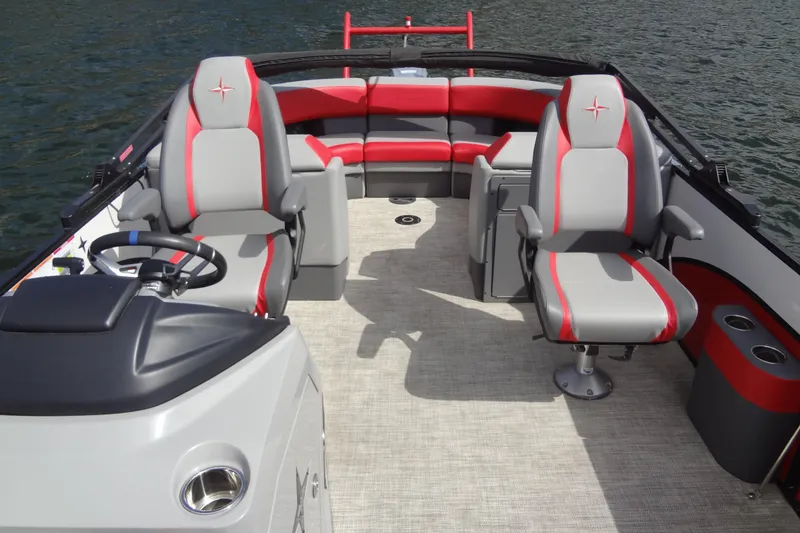 Slide: The Image of 2022 Berkshire 25RFX STS 3.0 boat interior with red and gray seating on the water. - 15