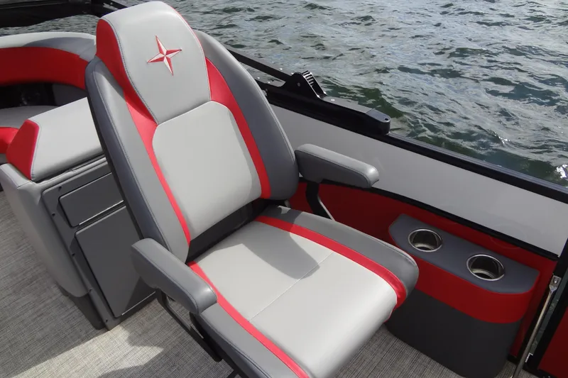 Slide: The Image of 2022 Berkshire 25RFX STS 3.0 boat seat with red and gray design by the water. - 16