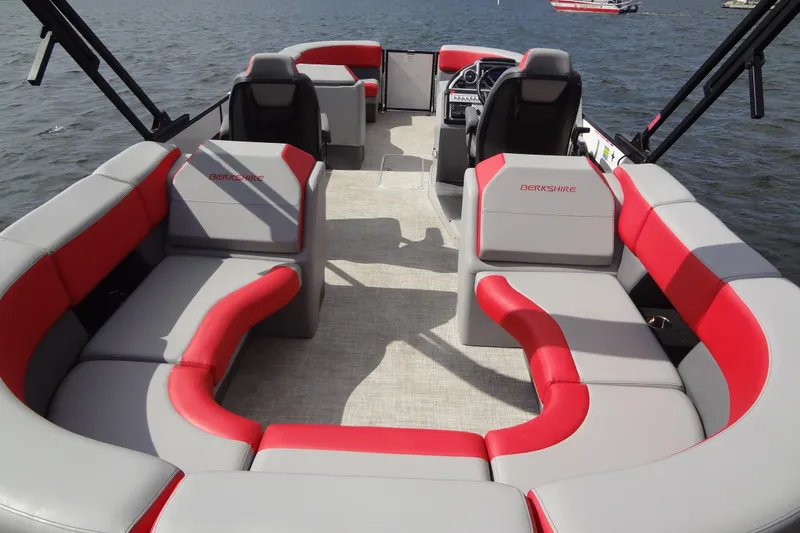 Slide: The Image of 2022 Berkshire 25RFX STS 3.0 pontoon boat with red and gray seating on a lake. - 26