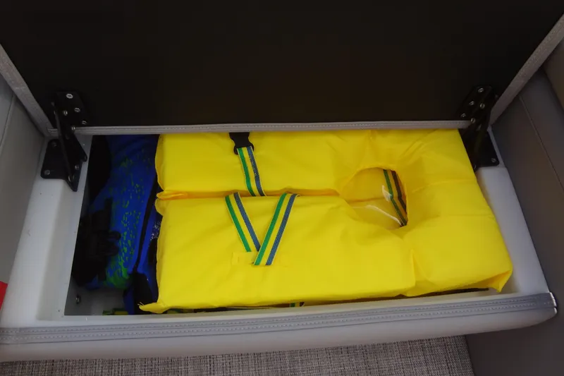 Slide: The Image of Storage compartment with yellow life jacket in 2022 Berkshire 25RFX STS 3.0 boat. - 42