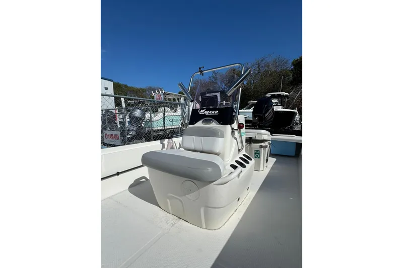 Slide: The Image of 2018 Mako Pro Skiff 17 CC boat interior with seating and console, outdoors. - 7