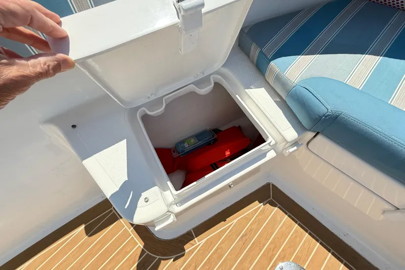 Slide: The Image of Storage compartment on 2017 Vanquish Bristol Harbor 23 CC boat, containing safety equipment. - 14