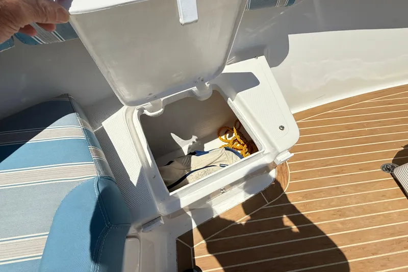 Slide: The Image of Open storage compartment on 2017 Vanquish Bristol Harbor 23 CC boat with striped seating. - 15