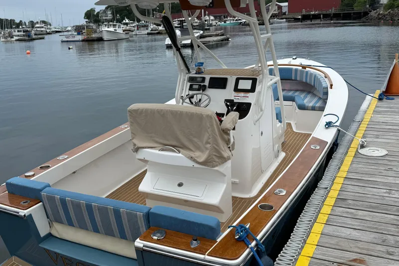 Slide: The Image of 2017 Vanquish Bristol Harbor 23 CC boat docked at a marina, featuring a sleek design. - 17