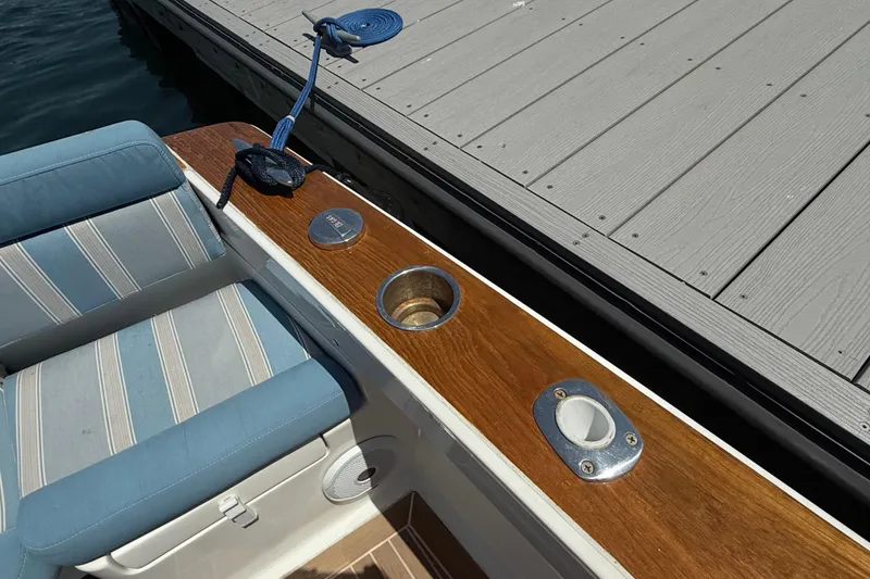 Slide: The Image of 2017 Vanquish Bristol Harbor 23 CC boat interior with striped seating and wooden trim. - 32