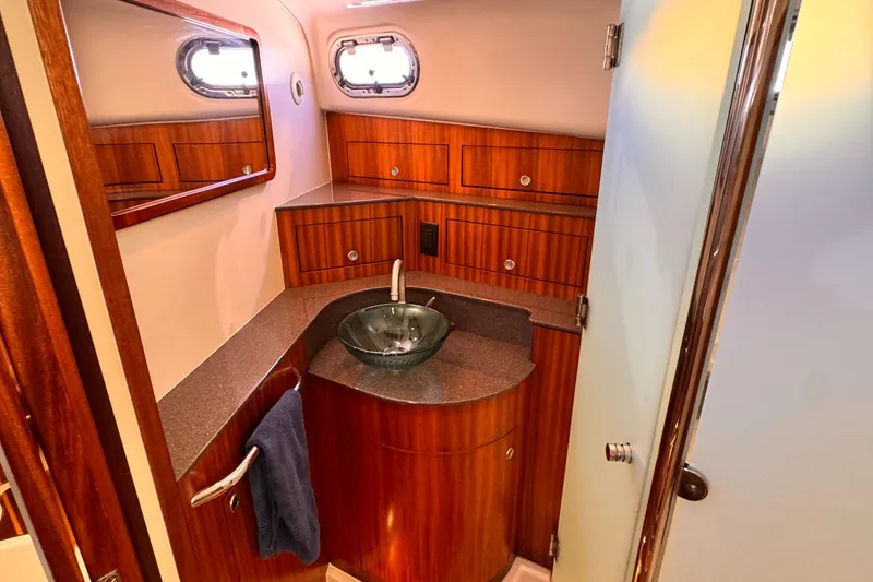 Slide: The Image of 2014 Pursuit OS 385 Offshore bathroom with wood cabinetry and modern sink. - 14
