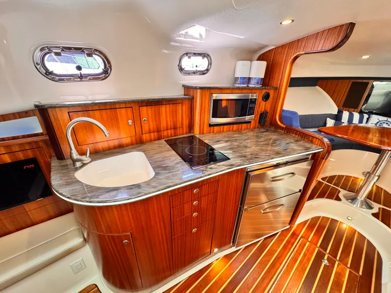 Slide: The Image of 2014 Pursuit OS 385 Offshore yacht kitchen with wood cabinetry and modern appliances. - 15