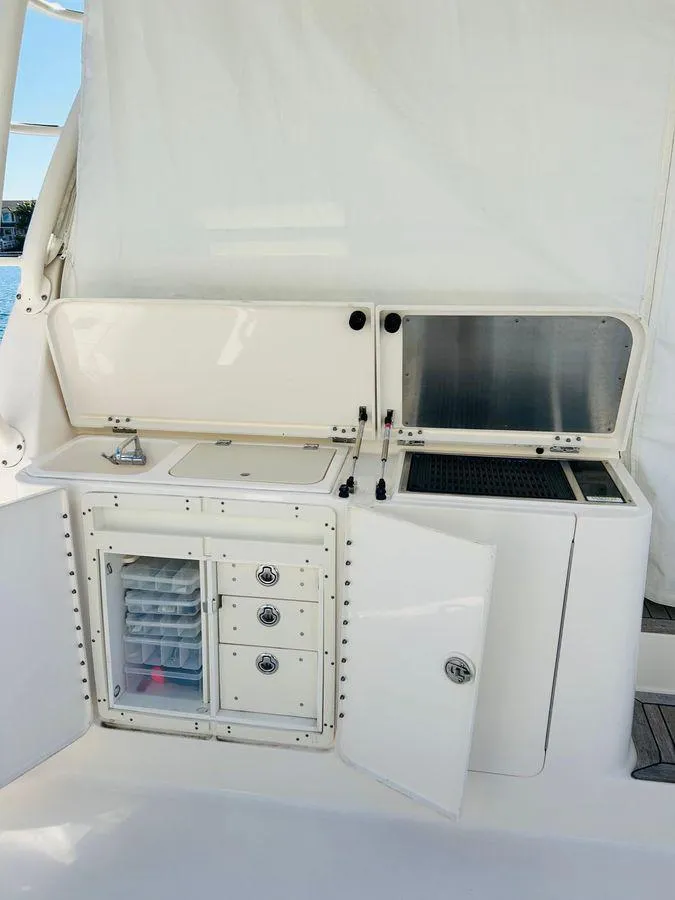 Slide: The Image of 2014 Pursuit OS 385 Offshore yacht kitchen with storage, sink, and grill. - 19