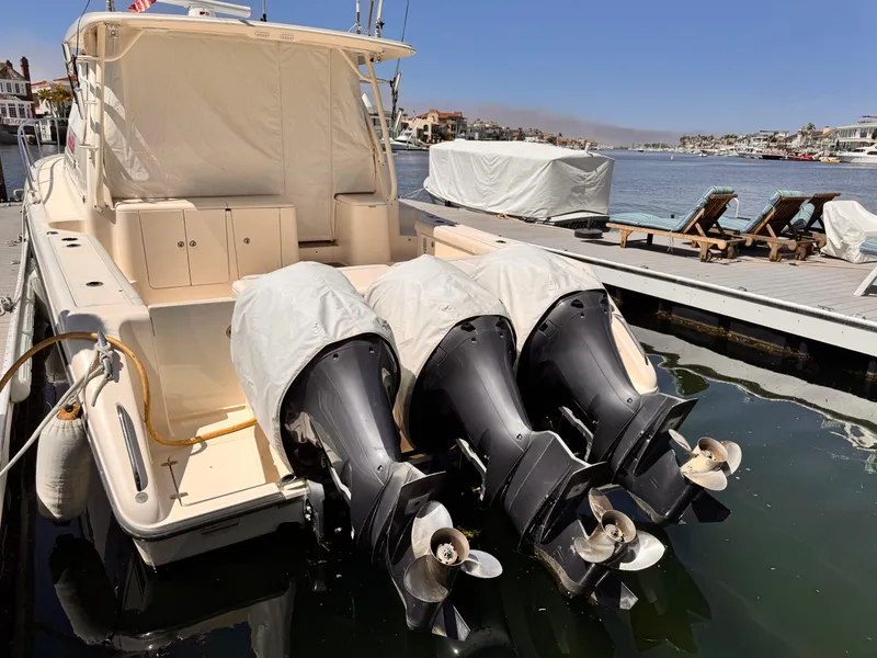 Slide: The Image of 2014 Pursuit OS 385 Offshore boat with triple outboard engines docked at marina. - 26