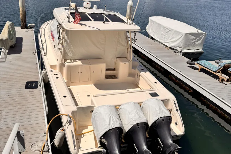 Slide: The Image of 2014 Pursuit OS 385 Offshore boat docked with triple outboard engines. - 3