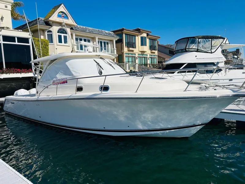 Slide: The Image of 2014 Pursuit OS 385 Offshore boat docked near waterfront homes. - 32