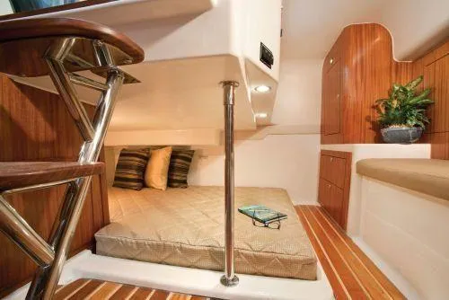 Slide: The Image of 2014 Pursuit OS 385 Offshore cabin interior with bed, wooden accents, and potted plant. - 5