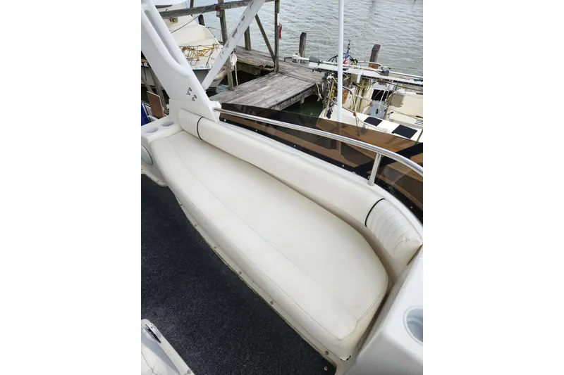 Slide: The Image of 1996 Silverton 34 Motor Yacht with white seating, docked by the water. - 10