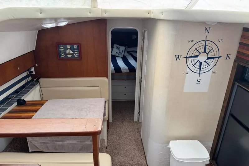 Slide: The Image of Interior of 1996 Silverton 34 Motor Yacht with compass wall art and cozy cabin. - 14