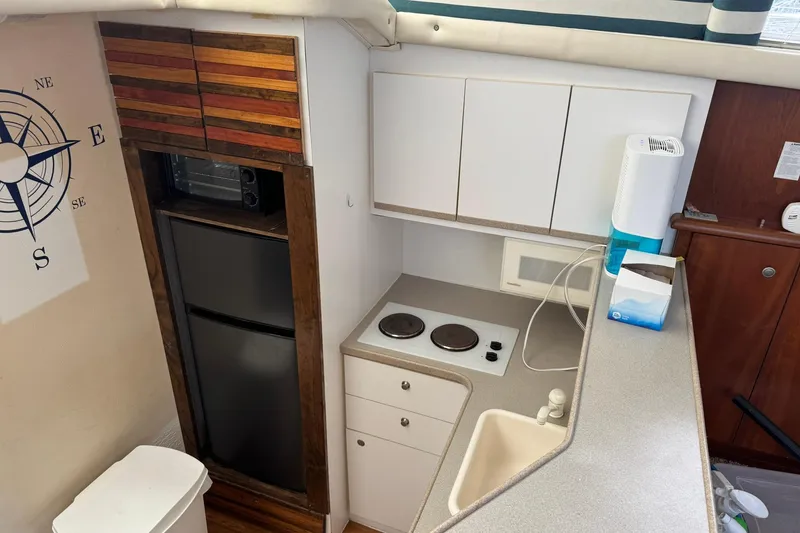 Slide: The Image of Interior of 1996 Silverton 34 Motor Yacht kitchen with appliances and compass wall art. - 16
