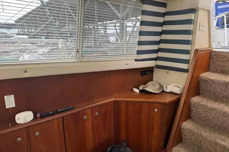 Slide: The Image of Interior of 1996 Silverton 34 Motor Yacht with wood paneling and striped cushions. - 23