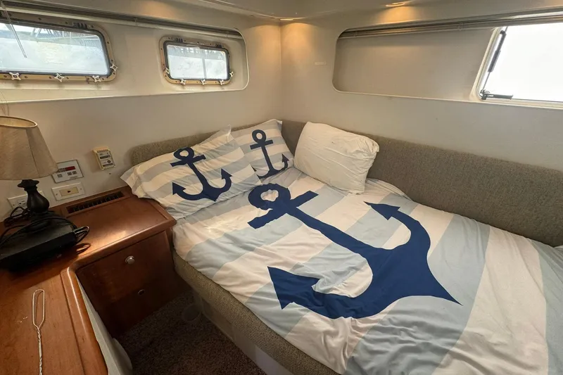 Slide: The Image of Cozy cabin interior of 1996 Silverton 34 Motor Yacht with nautical-themed bedding. - 24