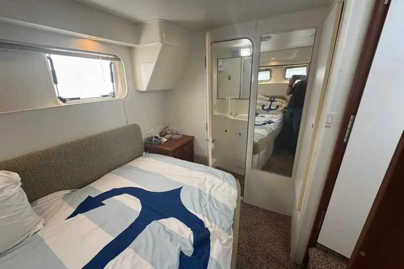 Slide: The Image of Interior of 1996 Silverton 34 Motor Yacht bedroom with nautical-themed bedding. - 25