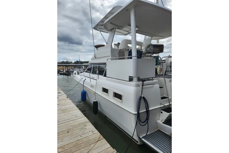Slide: The Image of 1996 Silverton 34 Motor Yacht docked at marina under cloudy sky. - 34