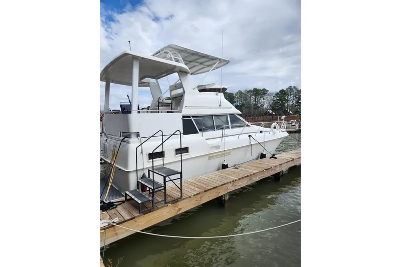 Slide: The Image of 1996 Silverton 34 Motor Yacht docked at marina under cloudy sky. - 5