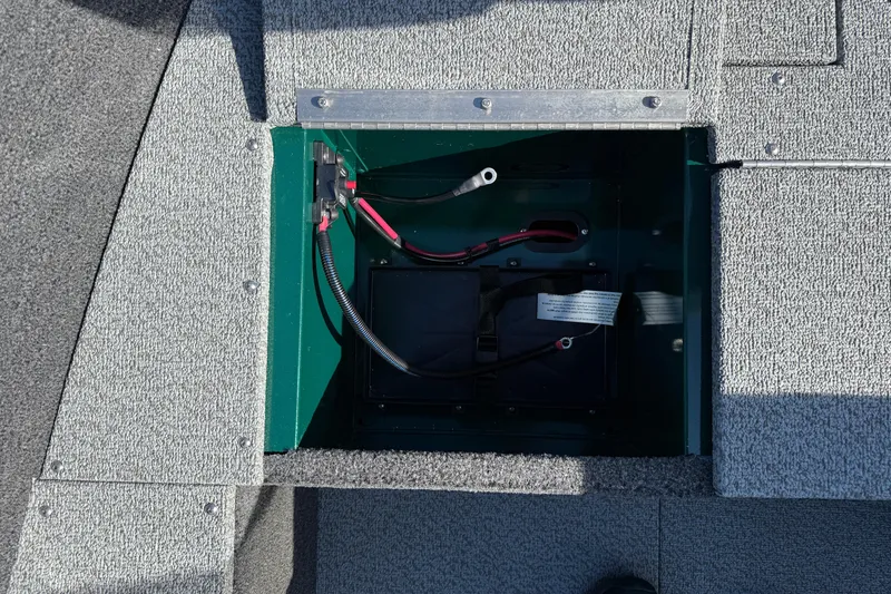 Slide: The Image of 2026 Lund 1650 Rebel XL SS boat battery compartment with wiring and secure fittings. - 12