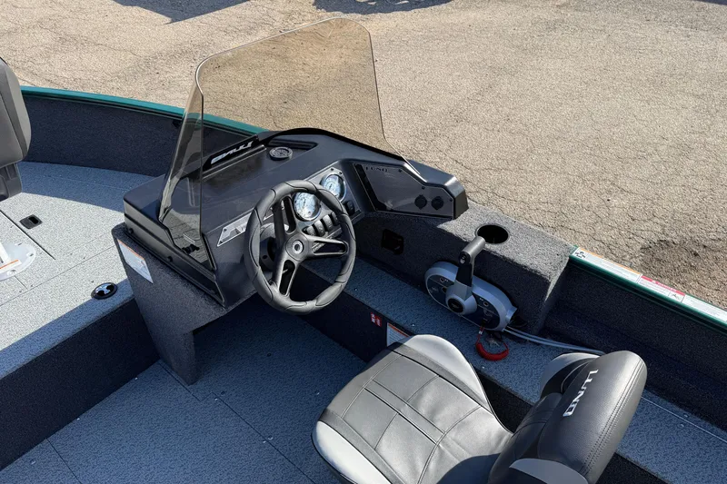 Slide: The Image of 2026 Lund 1650 Rebel XL SS boat interior with steering wheel and controls. - 16