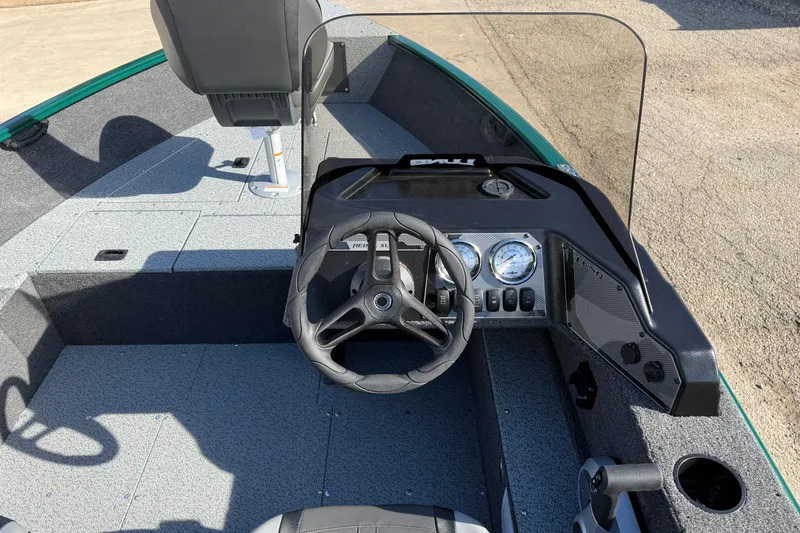 Slide: The Image of 2026 Lund 1650 Rebel XL SS boat interior with steering wheel and dashboard controls. - 17