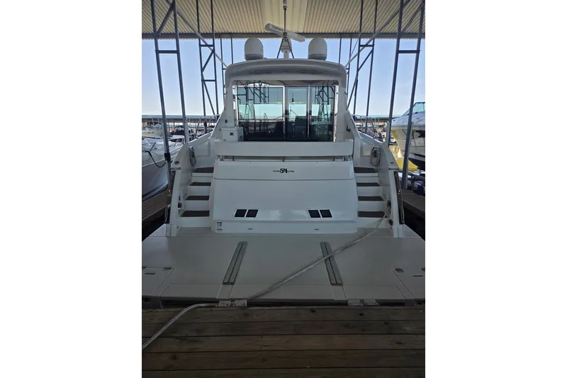 Slide: The Image of 2018 Cruisers Yachts 54 Cantius docked, rear view showing spacious deck and stairs. - 6