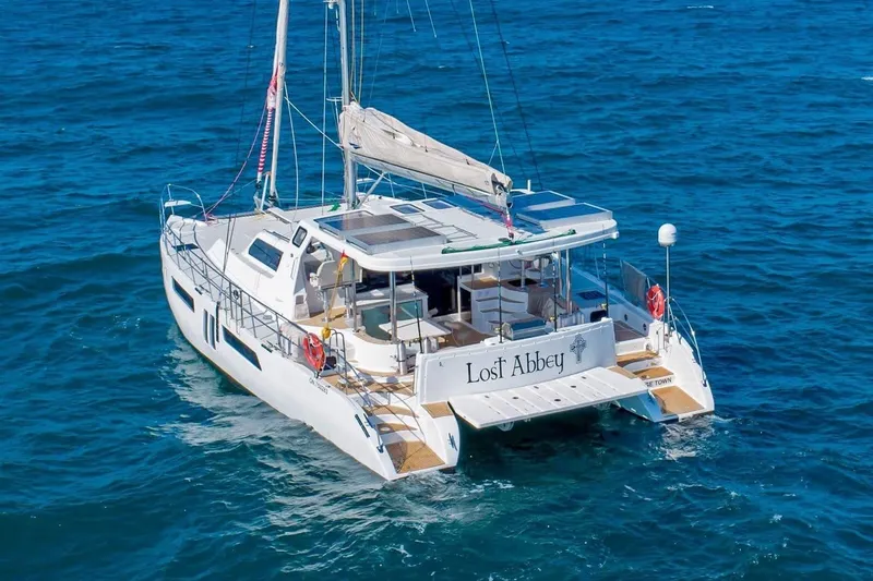 Slide: The Image of 2021 Royal Cape Catamarans Majestic sailing on open sea, featuring "Lost Abbey" name. - 10