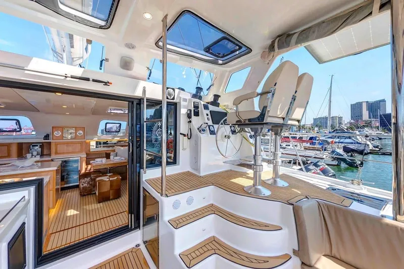 Slide: The Image of Luxurious 2021 Royal Cape Catamarans Majestic interior with helm, seating, and marina view. - 19