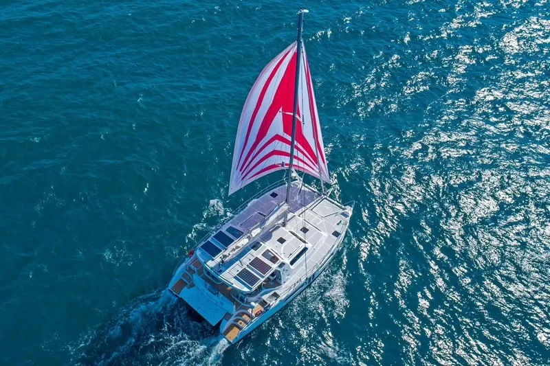 Slide: The Image of 2021 Royal Cape Catamarans Majestic sailing on open blue sea with vibrant red and white sail. - 9