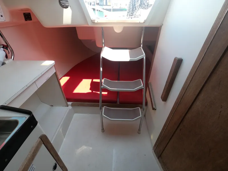 Slide: The Image of Interior of a 1998 Catalina 250 yacht with red bedding. - 11