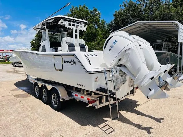 Slide: The Image of 2026 Tidewater 302 CC Adventure boat on trailer, featuring dual engines. - 2
