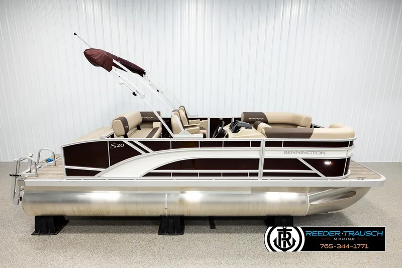 The Image of 2026 Bennington SSBSF pontoon boat with beige seating and maroon accents in showroom. - 1