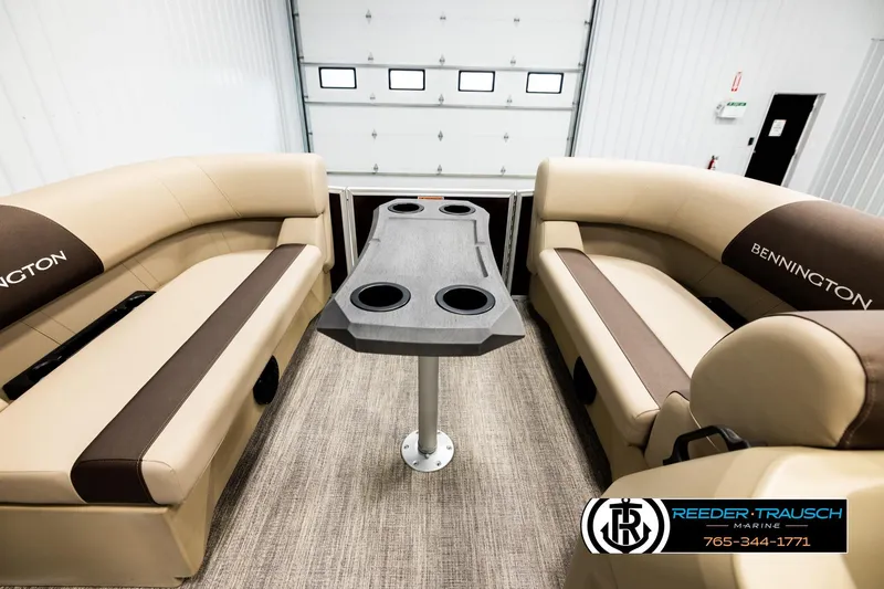 Slide: The Image of 2026 Bennington SSBSF boat interior with beige seating and central table in showroom. - 19