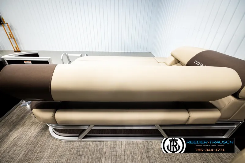 Slide: The Image of 2026 Bennington SSBSF boat interior with beige and brown seating, Reeder-Trausch Marine logo. - 21
