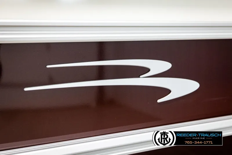 Slide: The Image of 2026 Bennington SSBSF boat logo on sleek brown surface, Reeder-Trausch Marine branding. - 48