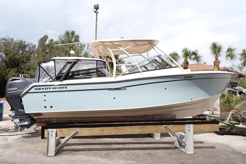The Image of 2016 Grady-White Freedom 275 boat on display with Yamaha engine, surrounded by palm trees. - 0