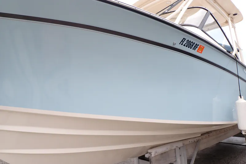 Slide: The Image of 2016 Grady-White Freedom 275 boat, light blue hull, docked on a trailer. - 115