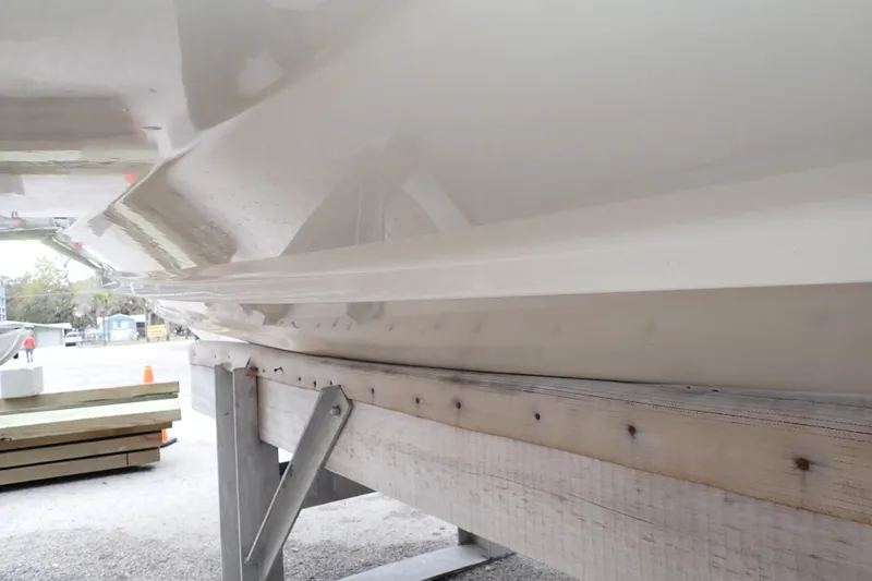 Slide: The Image of 2016 Grady-White Freedom 275 boat hull on a wooden support structure. - 121