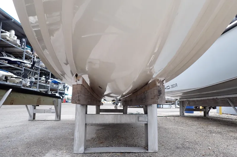 Slide: The Image of 2016 Grady-White Freedom 275 boat hull on storage stand in marina. - 125