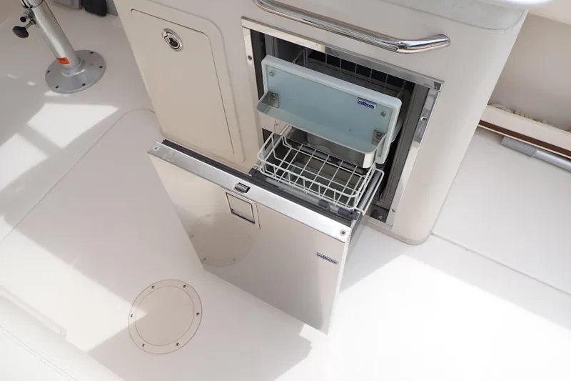 Slide: The Image of 2016 Grady-White Freedom 275 boat with open stainless steel refrigerator drawer. - 25