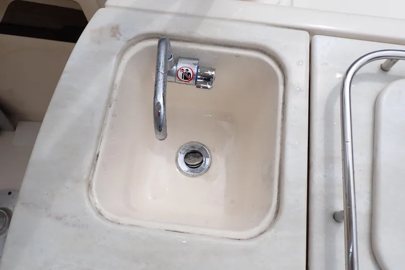 Slide: The Image of Sink on 2016 Grady-White Freedom 275 boat, featuring a chrome faucet and drain. - 27