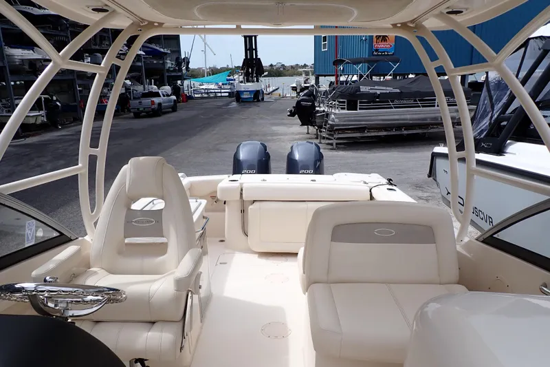 Slide: The Image of 2016 Grady-White Freedom 275 boat interior with dual engines at a marina. - 4