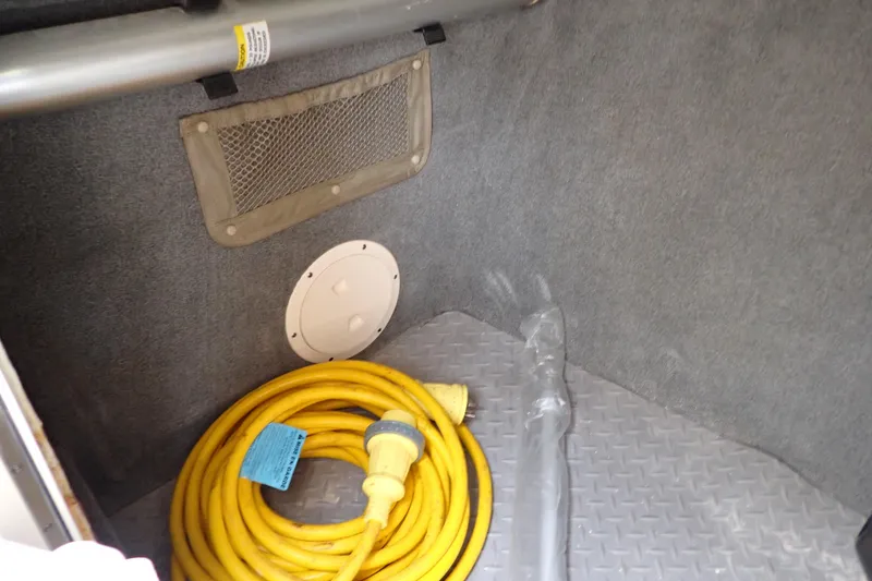 Slide: The Image of Storage compartment in a 2016 Grady-White Freedom 275 boat with coiled yellow power cable. - 55