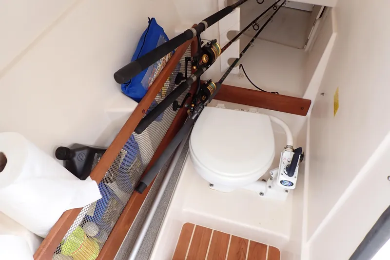 Slide: The Image of 2016 Grady-White Freedom 275 boat interior with fishing rods and marine toilet. - 9