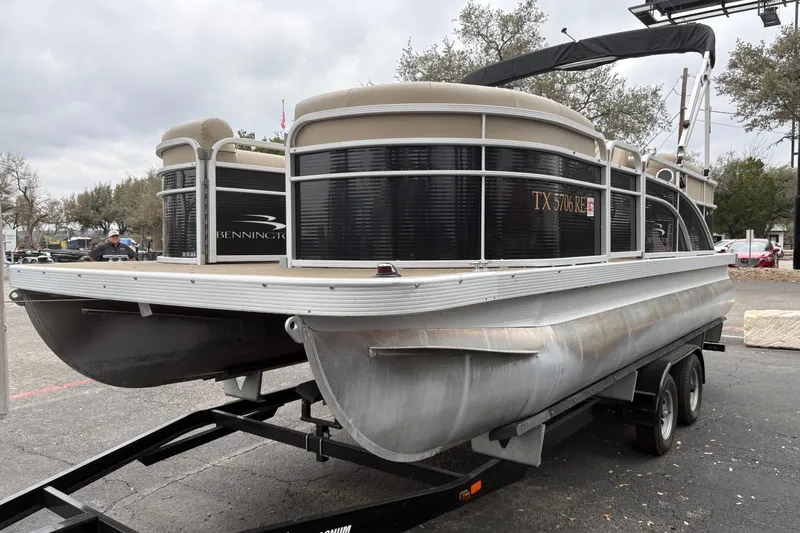 Slide: The Image of 2015 Bennington 20 SLMX pontoon boat on trailer, parked outdoors. - 3